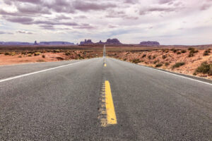 Highway 163 am Forrest Gump Point mit Monument Valley in der Ferne, einem der bekanntesten Filmdrehorte in Utah.